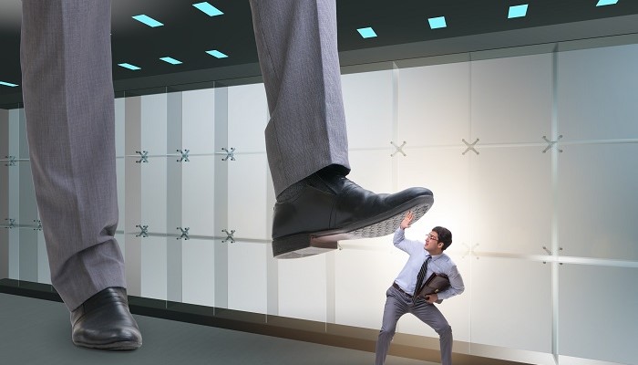 Giant foot of supervisor stepping on a male employee