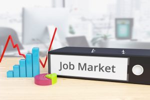 Job Market  – Finance/Economy. Folder on desk with label beside diagrams. Business/statistics.